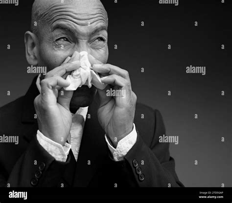 man catching the cold and flu man blowing nose after catching a cold with grey background with ...