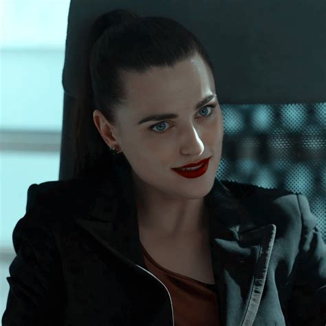 a woman sitting in a chair with red lipstick on her face and black jacket over her shoulders