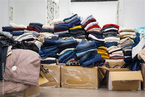 Stock clothing - A collection jeans, sweaters, jackets in modern distribution warehouse in the ...