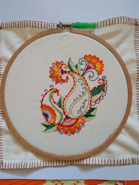 the embroidery on the wall is decorated with flowers and paisleys in orange, green, red, yellow ...