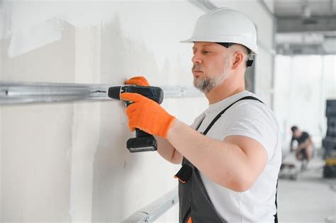 Premium Photo | Worker install a plasterboard wall