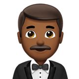 🤵🏾‍♂️ 턱시도를 입은 남자: 진한 갈색 피부 Emoji on Apple iOS 15.4