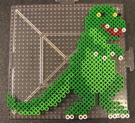 a lego model of a green dinosaur sitting on top of a black surface with ...