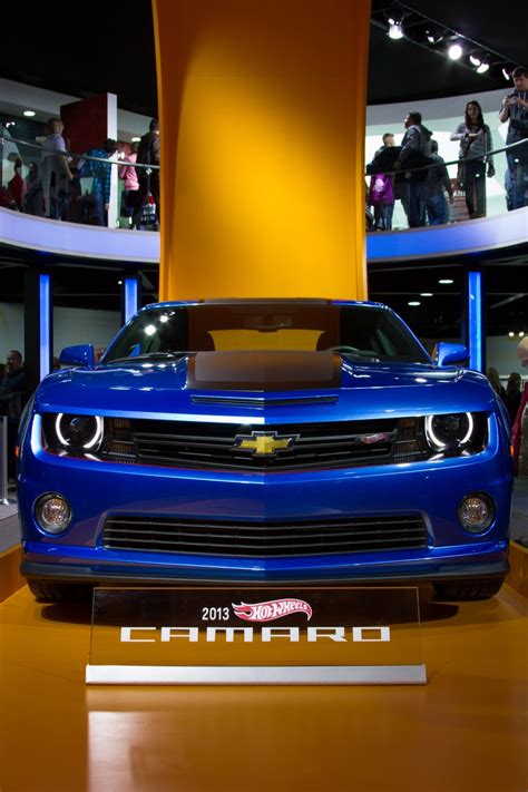 a blue chevrolet camaro is on display at an auto show