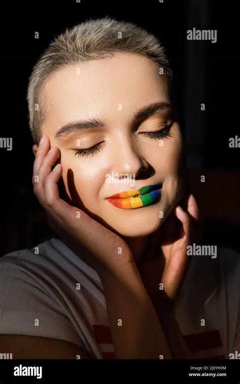 young woman with rainbow colors lips and hands near face isolated on ...