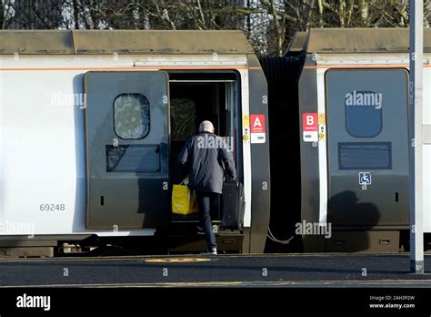 A passenger boarding a Avanti West Coast Pendolino train, in grey livery before rebranding ...