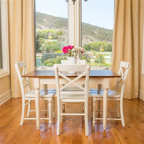 a dining room table with four chairs and a chandelier