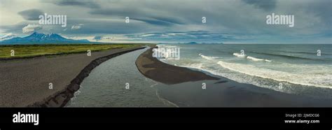 Beach with black sand and volcano Stock Photo - Alamy