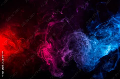 abstract shapes of mixed colors of blue and red smoke at dark ...