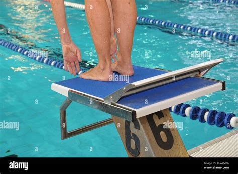 Close-up shot of human legs on the starting block of the swimming pool ready to jump Stock Photo ...