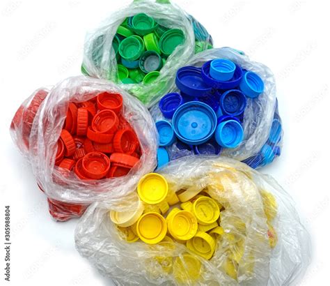 Colorful plastic bottle caps sorted by colors in transparent single use plastic bags. PP an PET ...