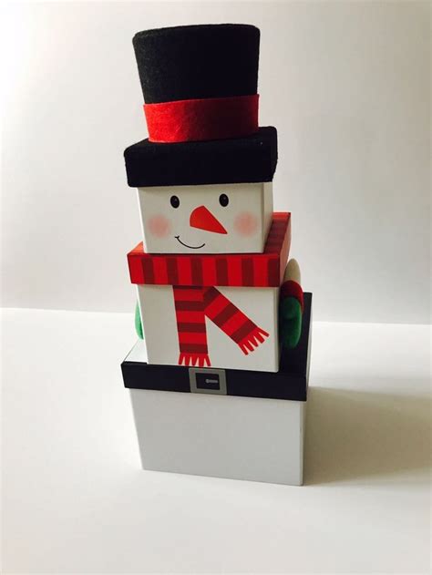 a snowman made out of paper on top of a white box with a red and black ...