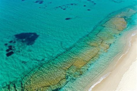 Kite surfing in the blue waters of Naxos at Mikri Vigla beach. Aerial view with headland and ...