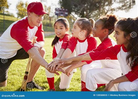 Girl Baseball Team Kneeling With Their Coach, Touching Hands Royalty-Free Stock Photo ...