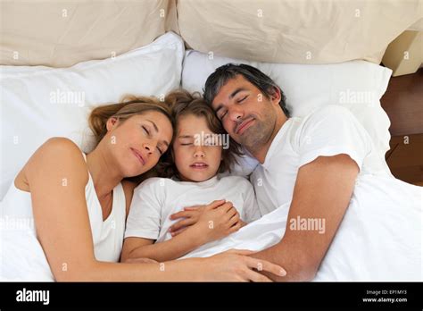 Cute child and his parents sleeping together Stock Photo - Alamy