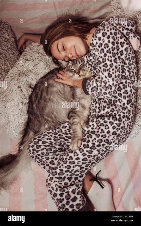 Girl pajamas hugging her cat laying bed Stock Photo - Alamy