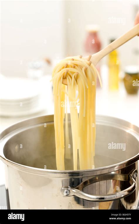 Woman boiling pasta Stock Photo - Alamy