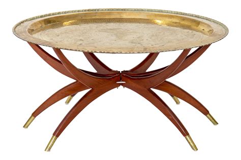 Mid-Century Moroccan-style oval tray top coffee table with "spider" base. The solid brass tray ...