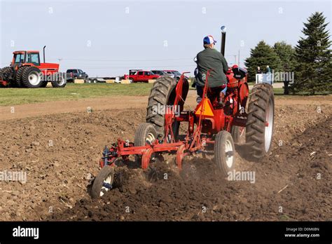 1950 Farmall, Model M, plowing a field with a 3-bottom plow on a farm ...