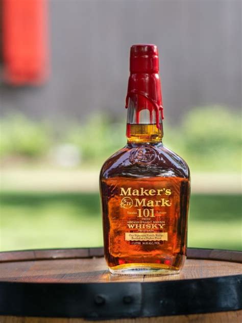 a bottle of maker's mark whiskey sitting on top of a barrel