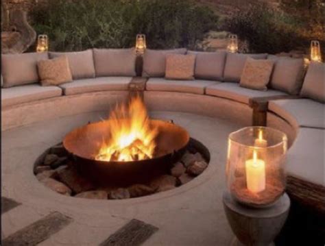 an outdoor fire pit with candles lit in it