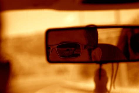 Premium Photo | Cropped image of man reflecting on rear-view mirror in car