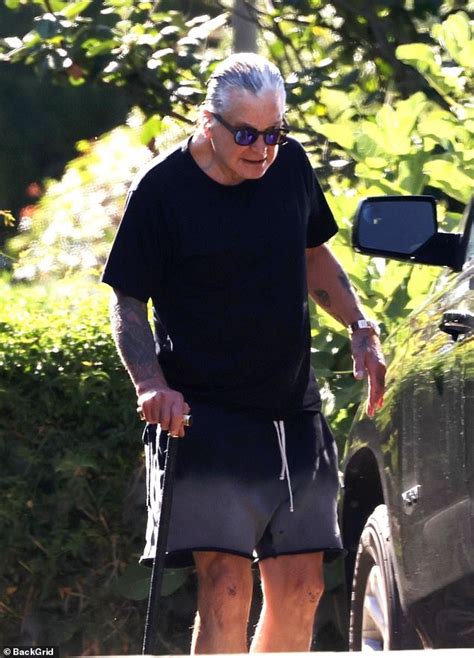 Ozzy Osbourne uses a cane on walk amid his battle with Parkinson's ...