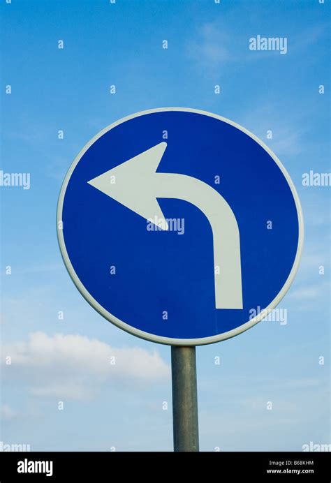 left turn road sign over blue sky Stock Photo - Alamy