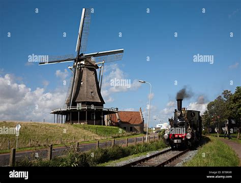 Steam train on tourist railway line with windmill Medemblik Netherlands Stock Photo - Alamy