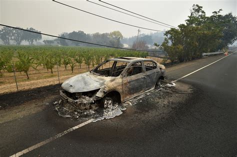 "Melted metal flows from a burned-out car abandoned on a highway during the Valley Fire in ...