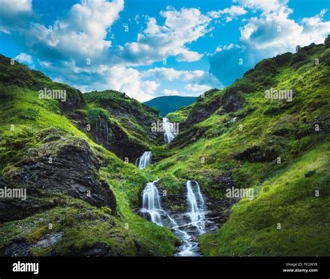 Waterfall, green hills and rolling clouds Stock Photo - Alamy