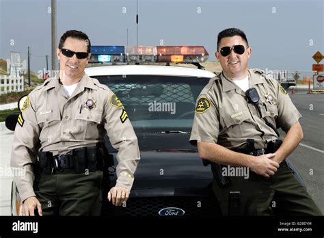 Two police officers standing in front of police car Stock Photo - Alamy