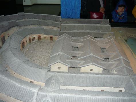 an elaborate model of a castle made out of cement blocks and sand with people standing around it