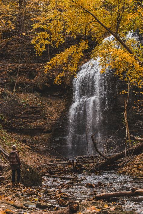 Browse Free HD Images of Hiker Looks Up At Waterfall In Fall