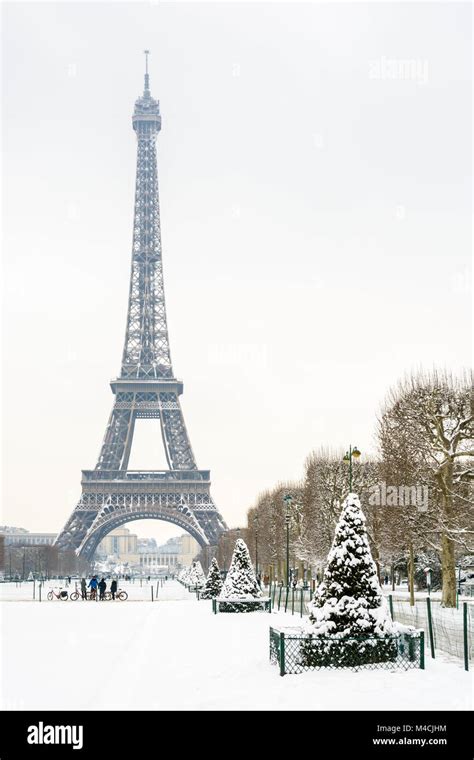 Winter in Paris in the snow. The Eiffel tower seen from the Champ de ...