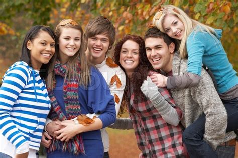 Group Of Six Teenage Friends Having Fun In Autumn Park | Stock Photo | Colourbox