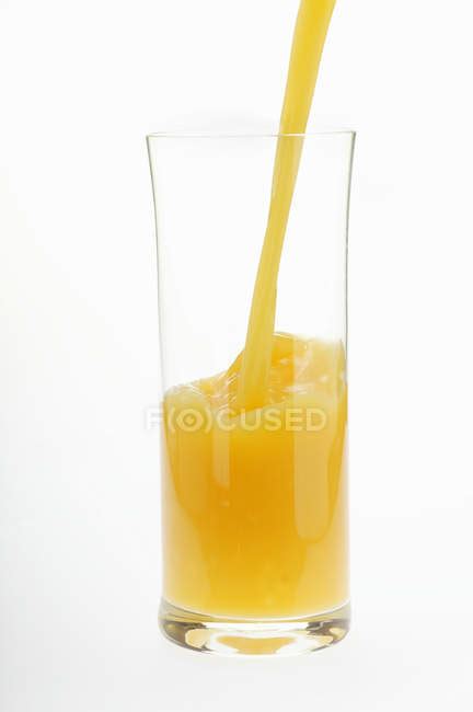 Pouring orange juice into glass — tropical fruit, freestanding - Stock ...