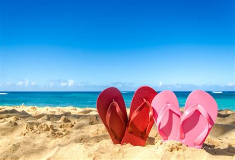 Premium Photo | Red and pink flip flops on the sandy beach