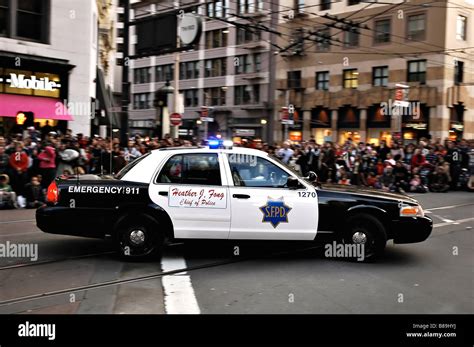 San Francisco police car carrying Police Chief Heather Fong driving in a parade with a crowd ...