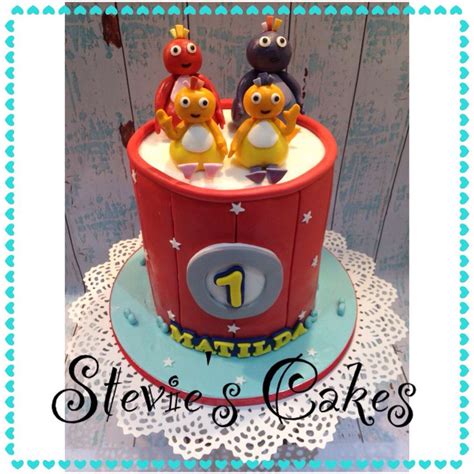 there is a cake that has the number one on it and three small figures ...