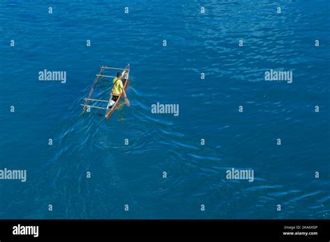 One person in traditional wooden dugout canoe fishing in Milne Bay ...