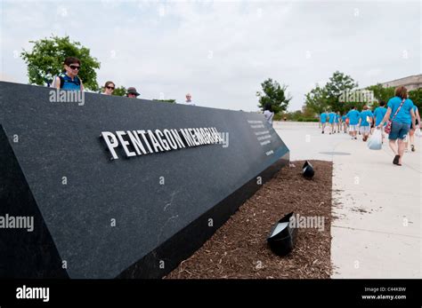 Visitors walk past the entrance sign of the Pentagon Memorial at the ...