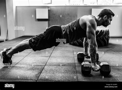 Muscular man doing pushup exercise with dumbbell Stock Photo - Alamy