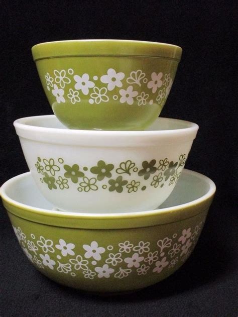 three green and white bowls stacked on top of each other with flowers painted on them