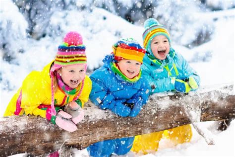 Kids Playing in Snow. Children Play Outdoors in Winter Snowfall. Stock ...