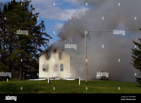 Volunteer firefighters fighting a house fire Stock Photo - Alamy