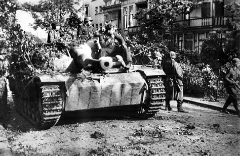 Soldiers of the 9th SS Panzer Division ride a Sturmgeschütz III through ...