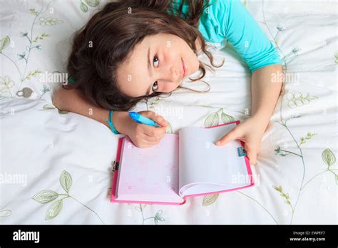 Girl writing diary in bed Stock Photo - Alamy