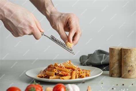 Premium Photo | Man cooking pasta grating cheese