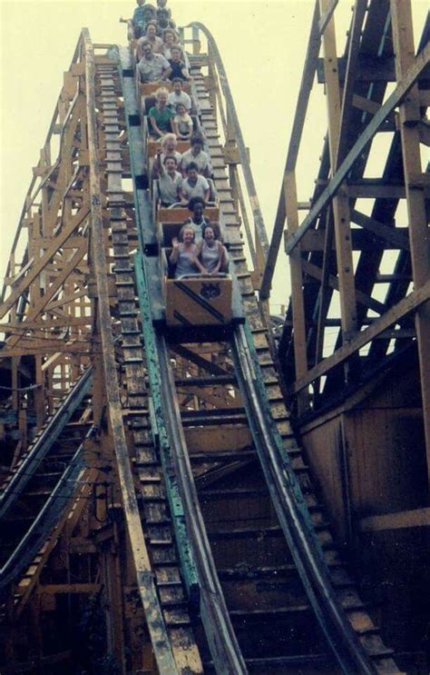 people are riding the roller coaster at an amusement park